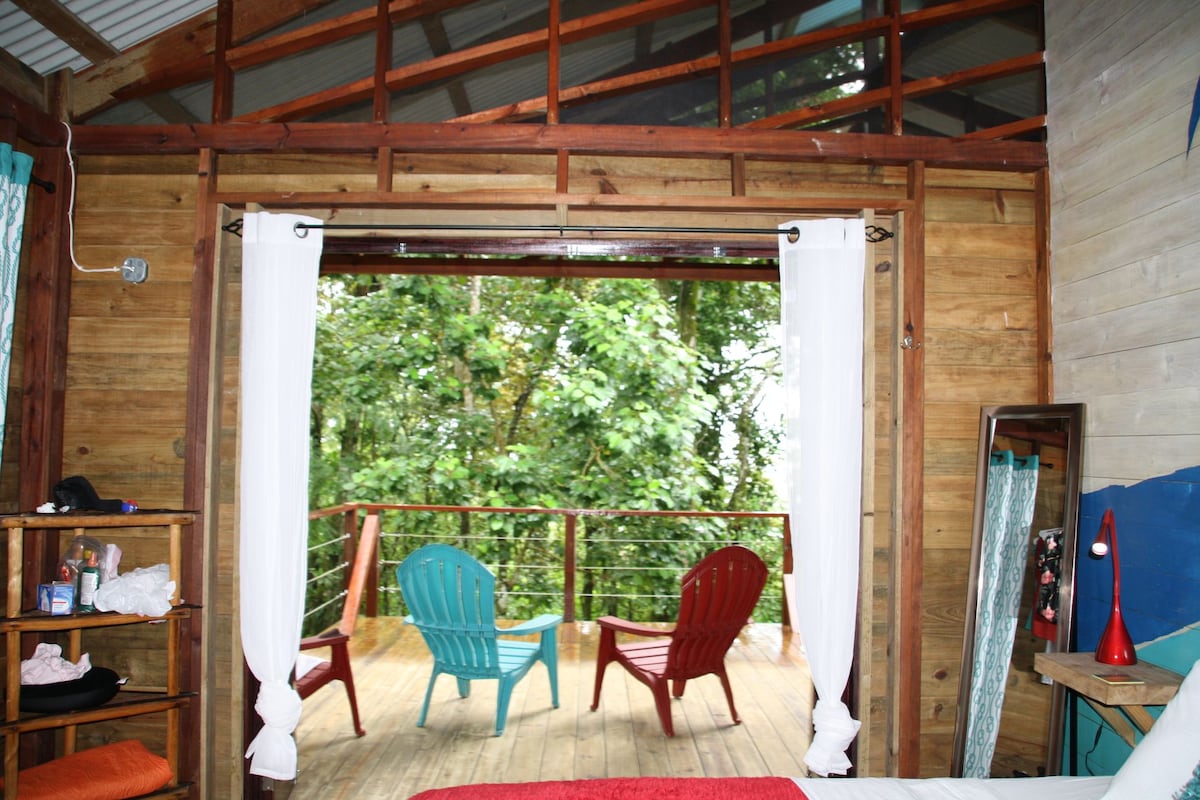 Open-air windows and tropical greenery inside Bungalow Left at SurfBreak at Paunch