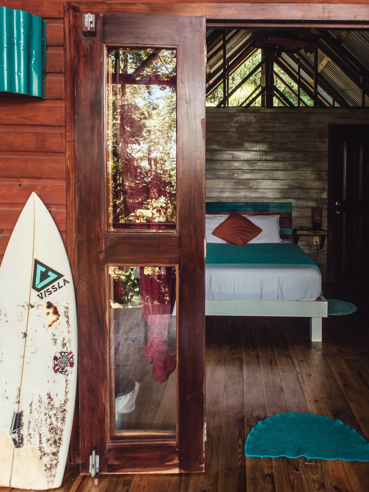 Rustic wood interior and surfboard detail inside the Tree Cabin at SurfBreak at Paunch