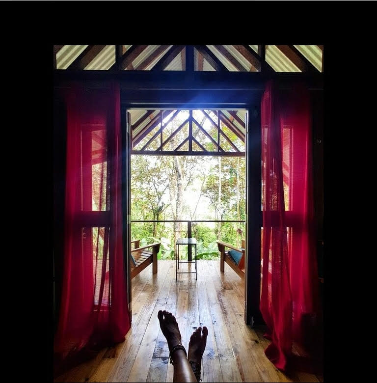 Large screened window and tropical jungle view inside the Tree Cabin at SurfBreak at Paunch