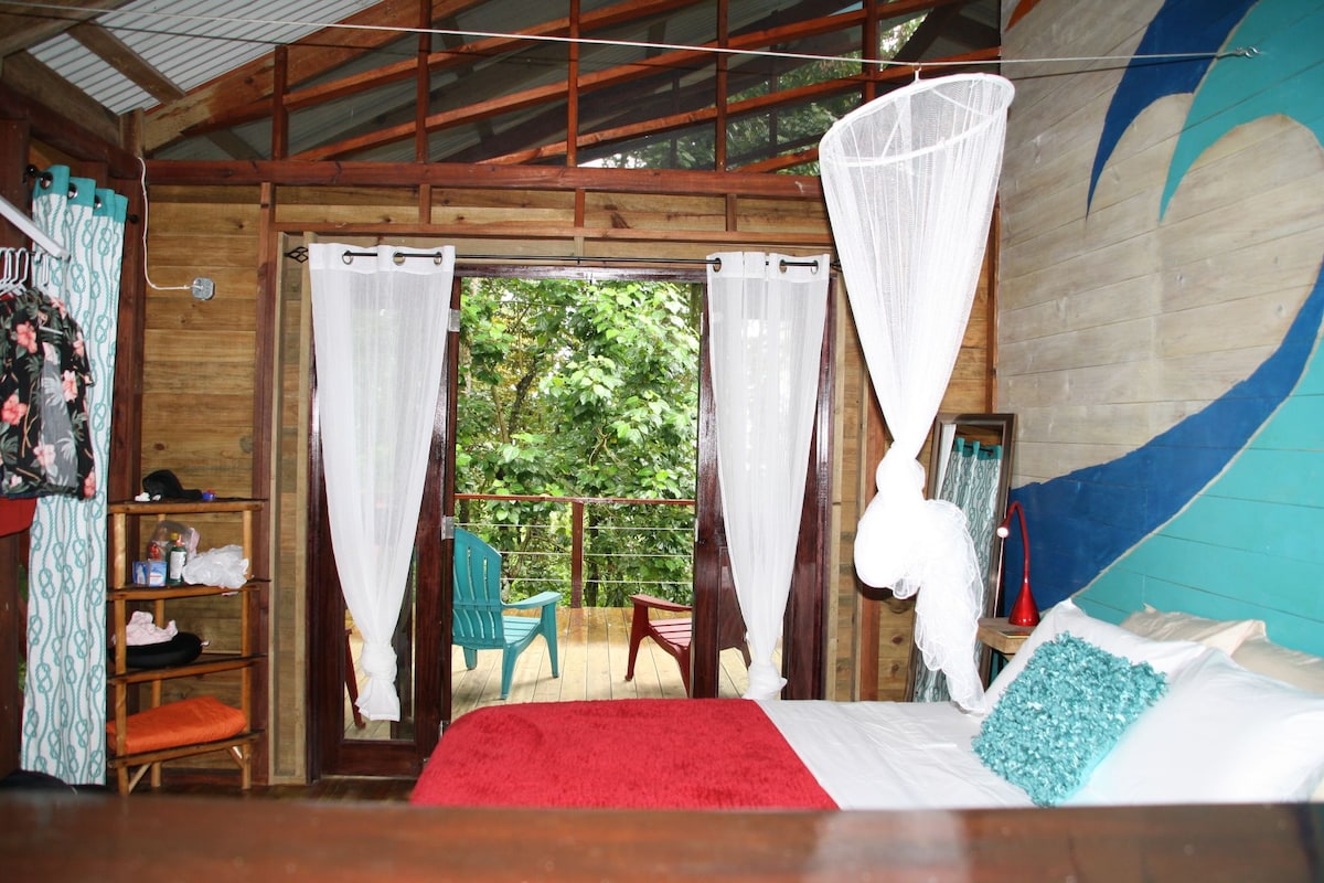Tropical interior and screened opening in Bungalow Left at SurfBreak at Paunch