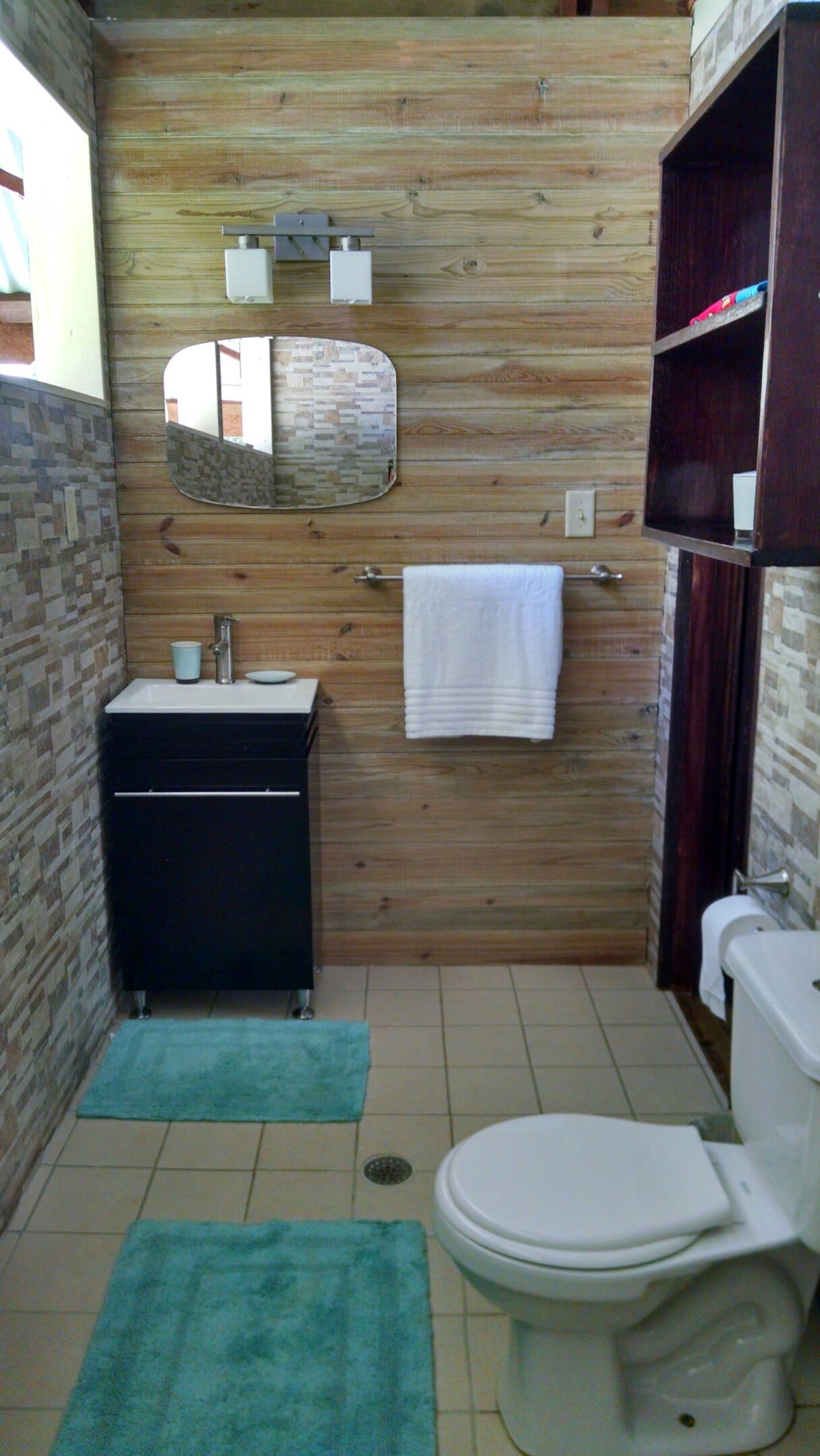 Private bathroom with wood walls in the Tree Cabin at SurfBreak at Paunch