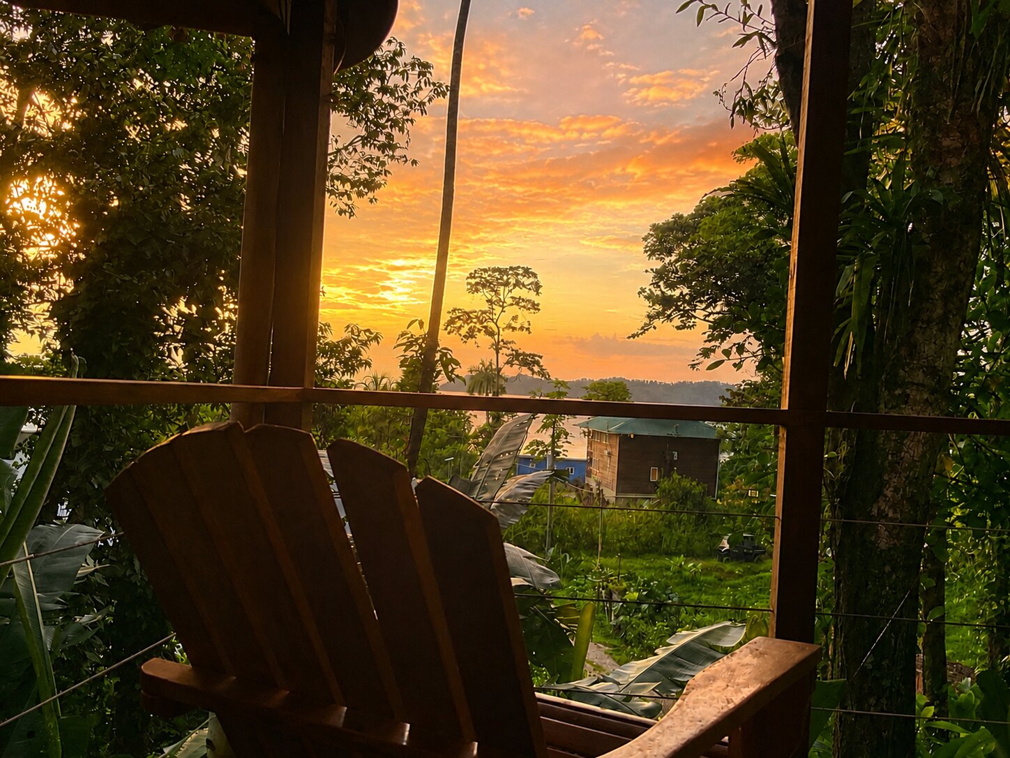 Sunset from a private porch at SurfBreak at Paunch, looking across jungle toward the Caribbean Sea
